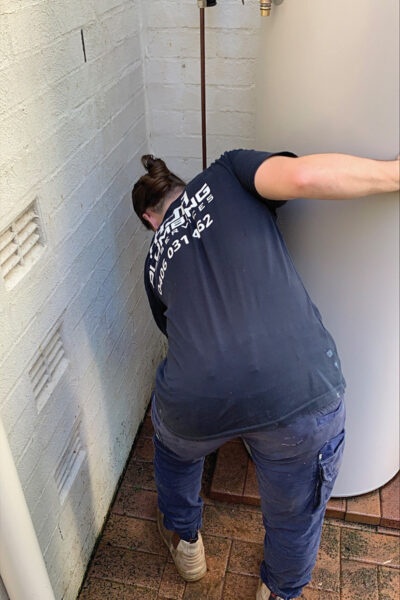 HJA plumber repairing pipework under a sink