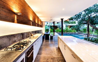 Outdoor kitchen with a stove an countertop next to garden